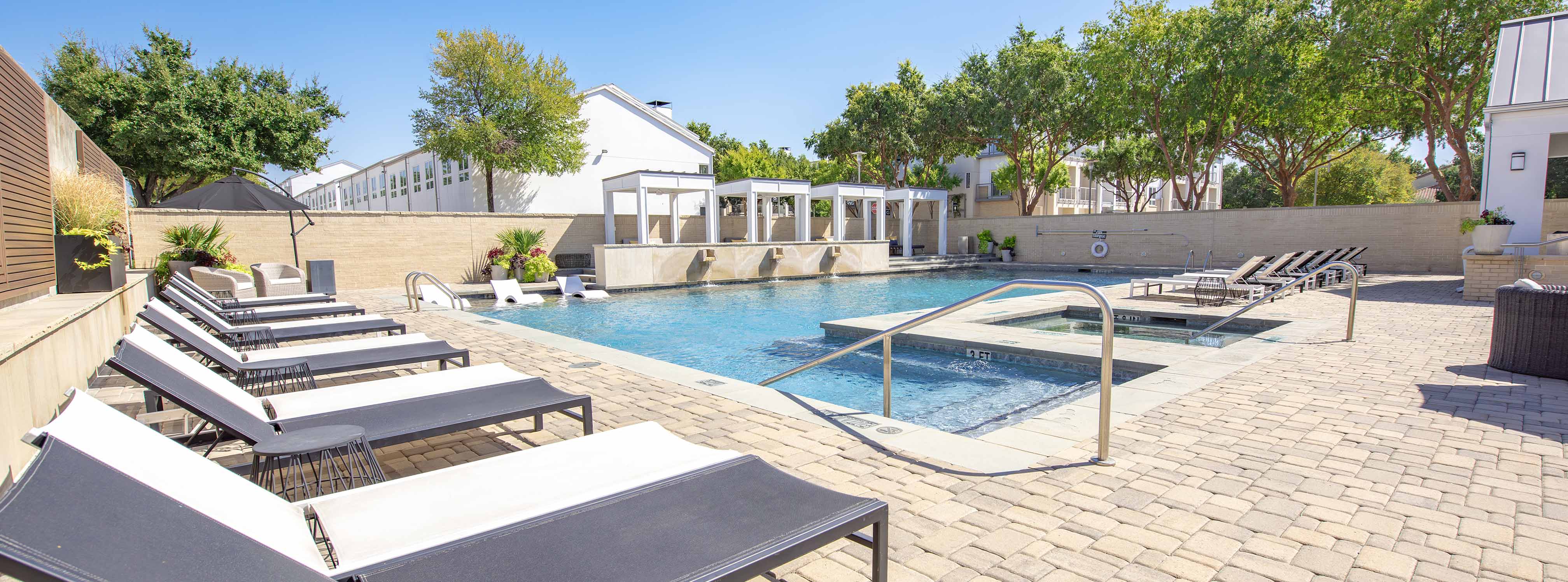 Pool with large sun deck and tons of seating and chaise lounge sun chairs
